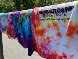 A row of tie-dyed summer camp t-shirts