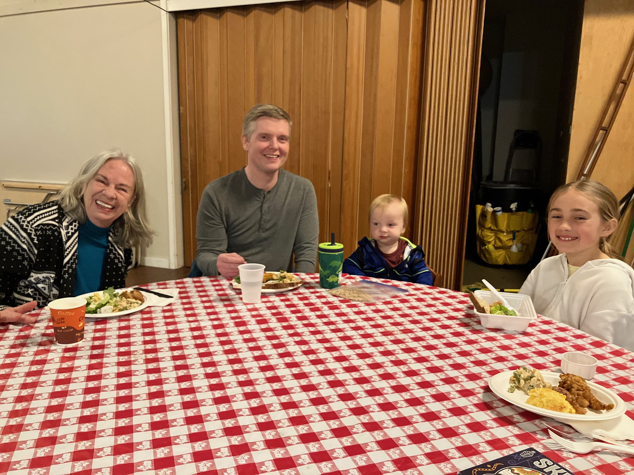 Kids and adults gathered at a table having dinner
