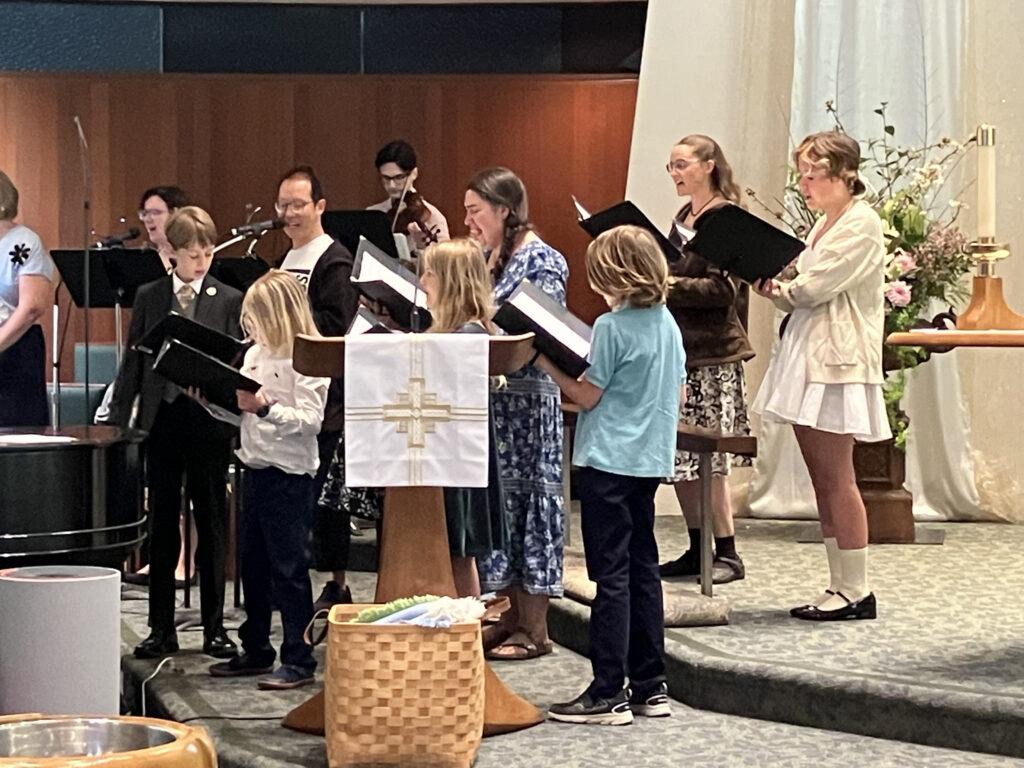 Children and adults singing in a choir together on Easter Sunday.