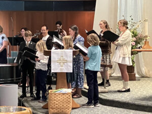 Children and adults singing in a choir together on Easter Sunday.