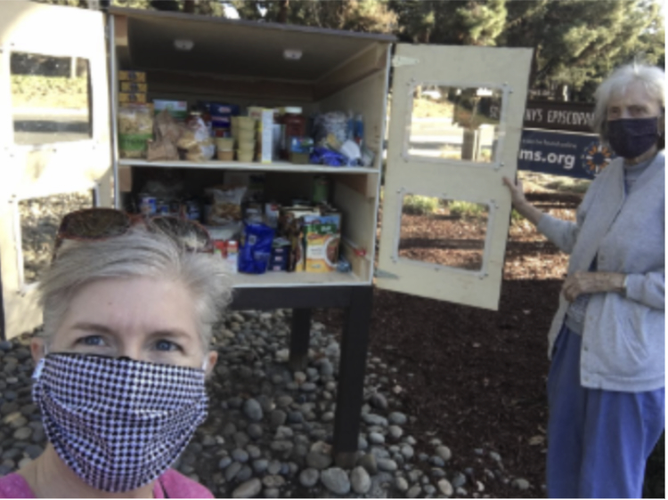 Two women standing in front of a food pantry with open doors