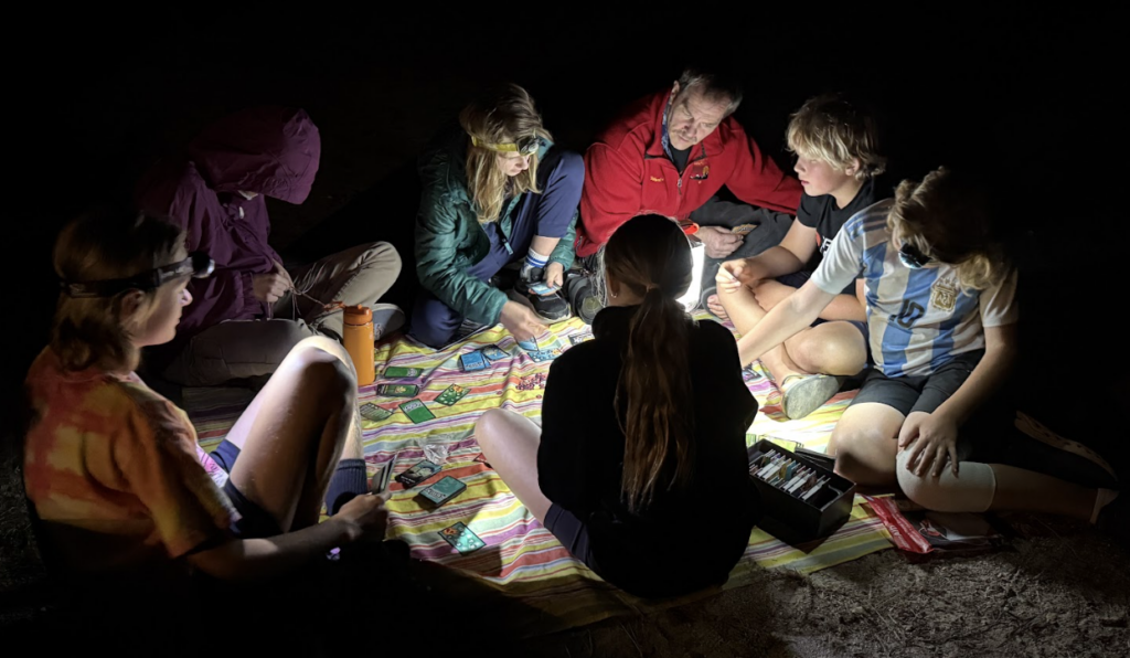 A group of youth playing a game in the dark on a camping trip