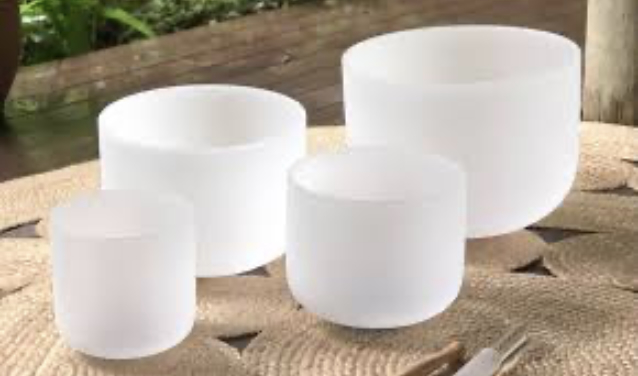 White singing bowls sitting on natural mats