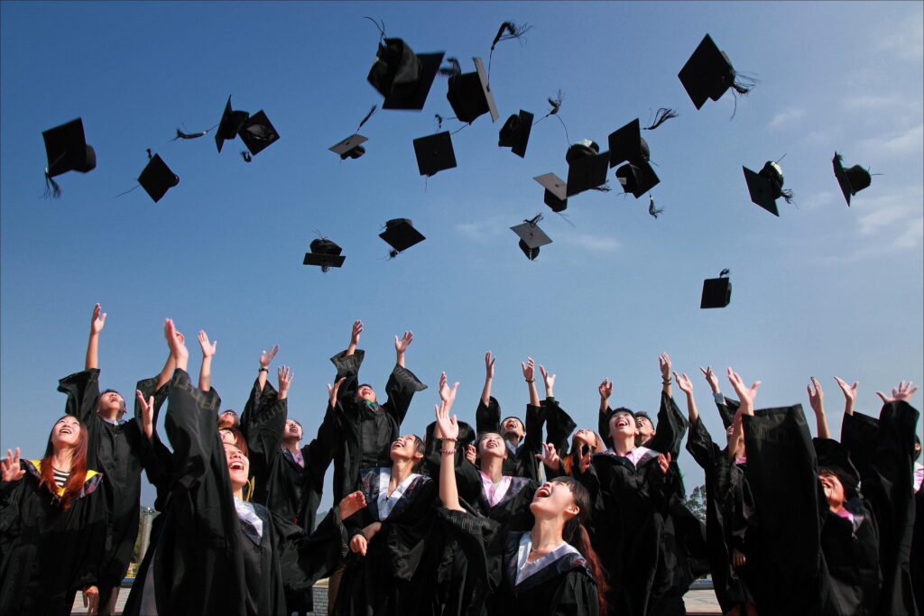 Students tossing graduation hats in the air