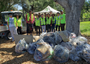 Many full garbage bags piled up in front of a team of volunteers