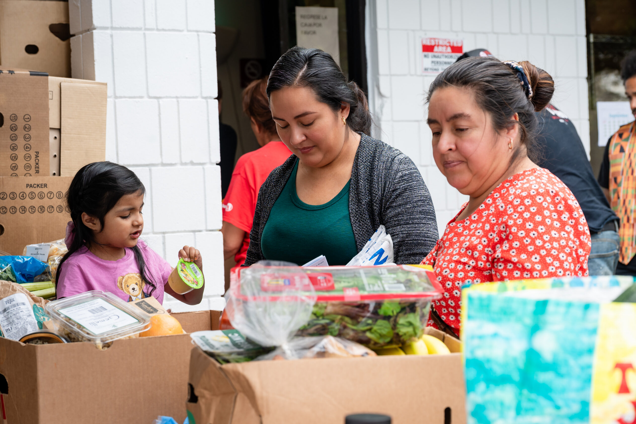 People giving and receiving food at a pantry at Santa Maria Urban Ministry
