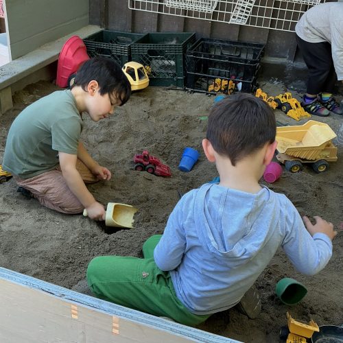 Two kids digging in a sandbox