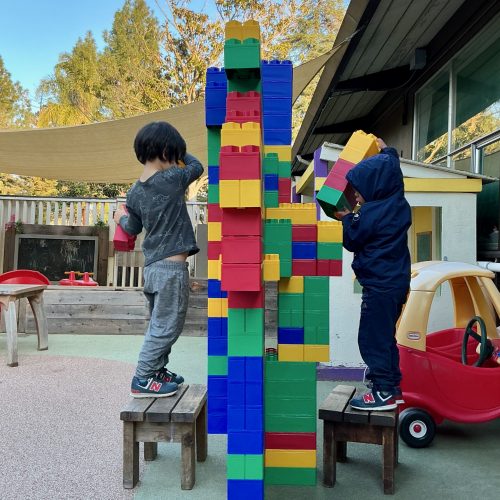 Kids building a block tower outside