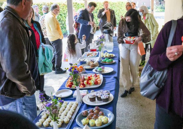 people gathered around a potluck table