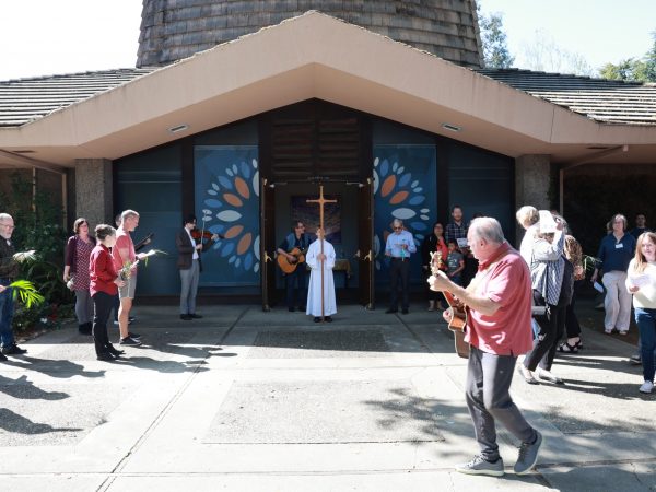 musicians and parishioners gather in front of the church